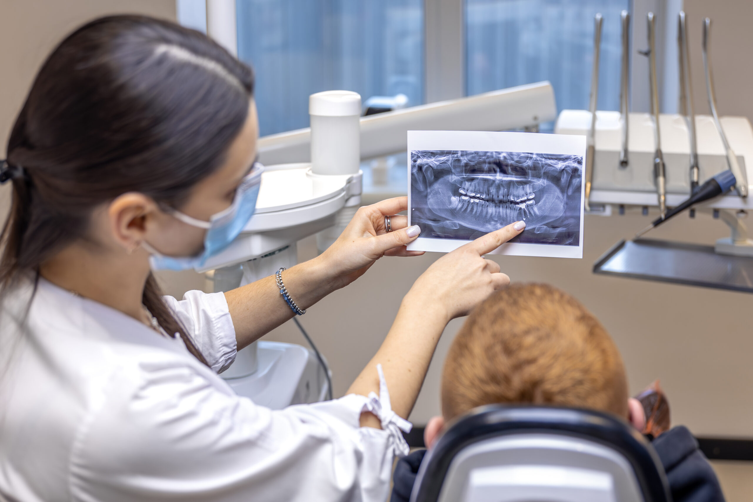 emale dentist explaining a dental X-ray to a patient in a clinic